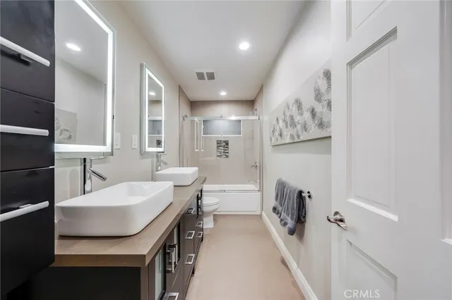 a bathroom with a sink a toilet a shower and a mirror