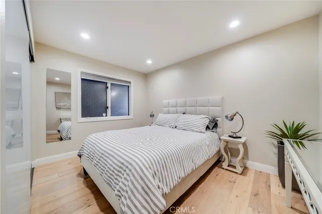 a bedroom with a large bed and a potted plant