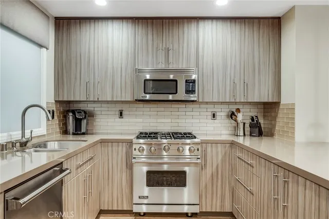 a kitchen with granite countertop a stove a sink and a microwave