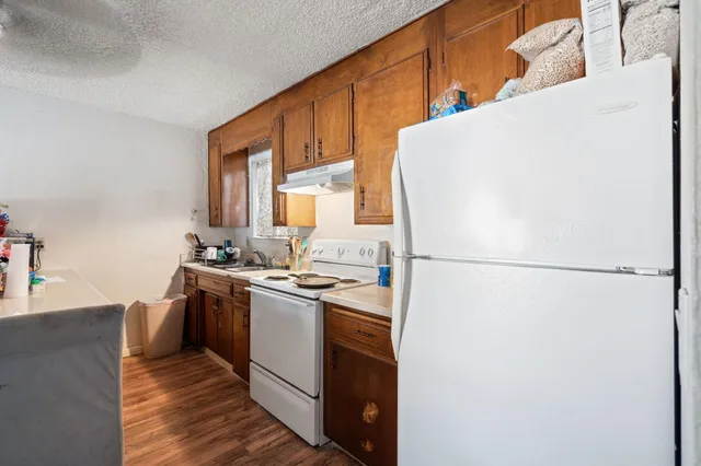 a kitchen with a refrigerator sink stove and cabinets