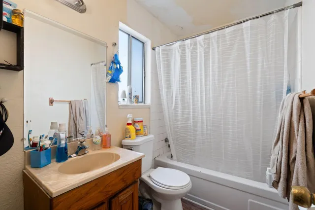 a bathroom with a sink a toilet and shower curtain