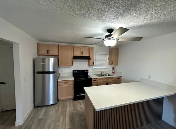 a kitchen with a refrigerator a sink dishwasher a stove and a refrigerator with wooden floor