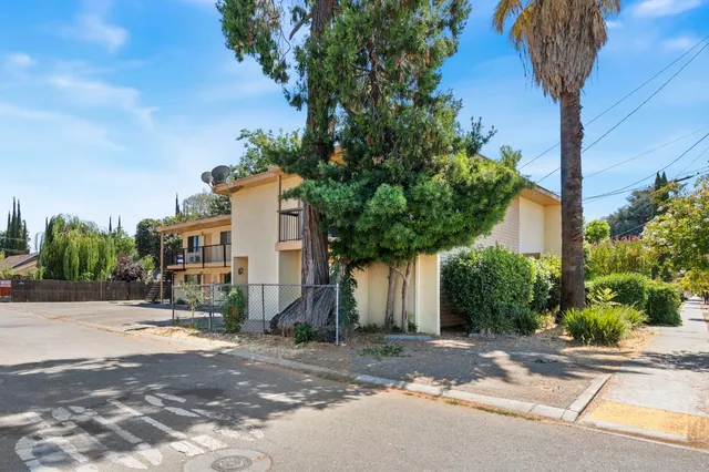 a view of a house with palm trees and a small yard