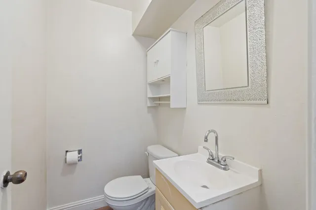 a bathroom with a sink mirror and toilet