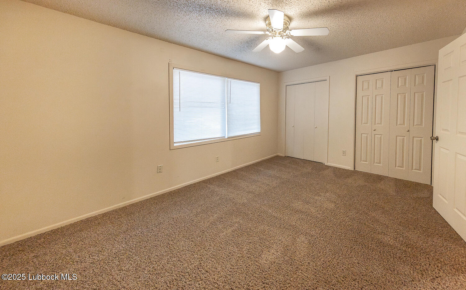 5750 38th Street Lubbock, TX 79407 - Photo 13 of 24 an empty room with windows and fan