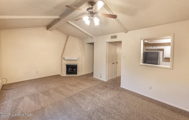 an empty room with a ceiling fan and entryway