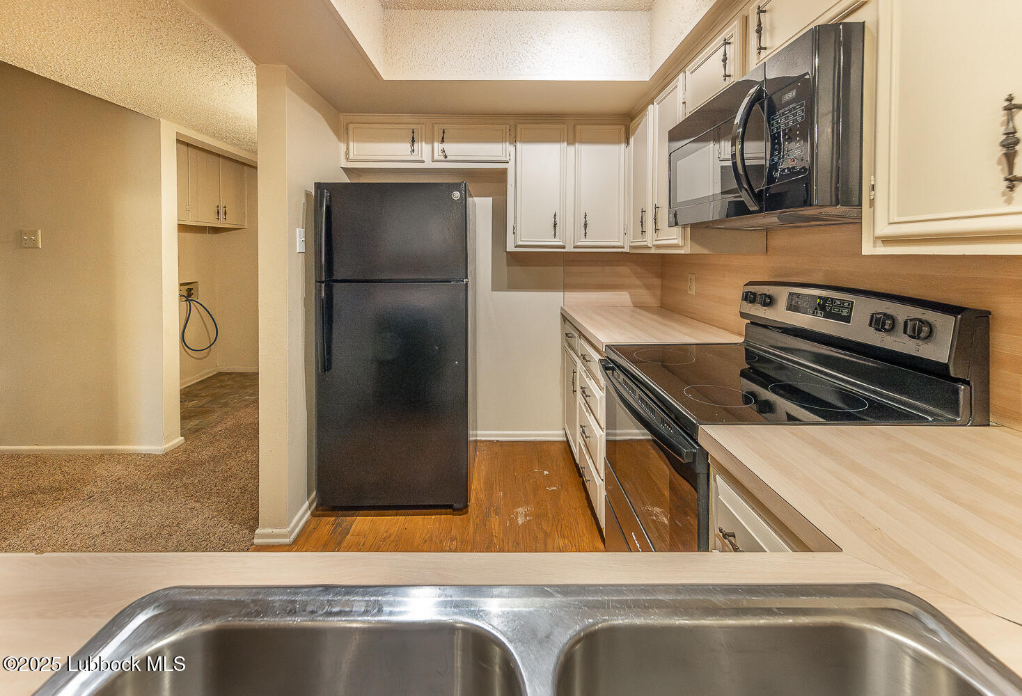 5750 38th Street Lubbock, TX 79407 - Photo 9 of 24 a kitchen with a refrigerator and a sink