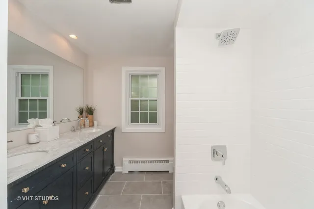 a bathroom with a sink mirror and a bathtub
