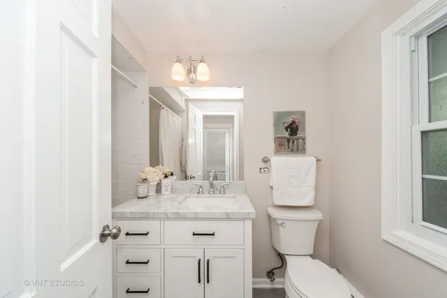 a bathroom with a granite countertop toilet sink and mirror