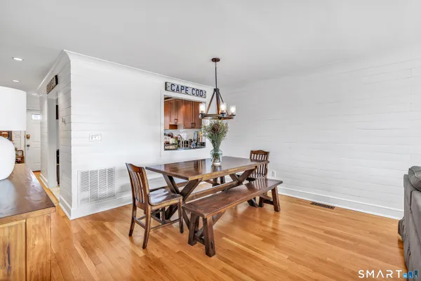 a dining room with furniture a chandelier and wooden floor