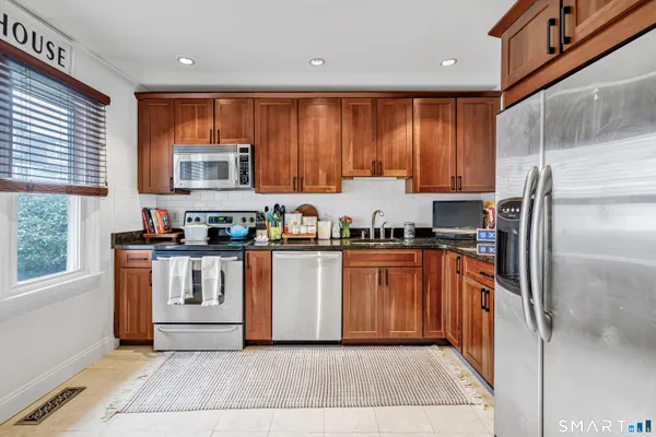 a kitchen with stainless steel appliances granite countertop a refrigerator sink and cabinets