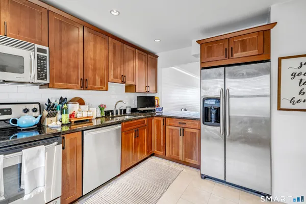 a kitchen with stainless steel appliances granite countertop a refrigerator and a sink