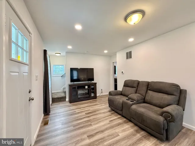a living room with furniture and wooden floor