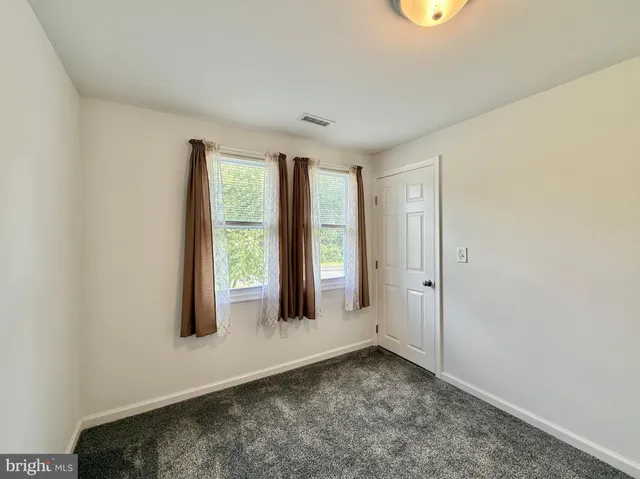an empty room with windows and cabinet