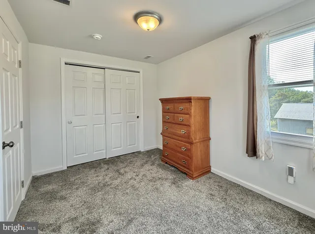 a spacious bedroom with a bed and a flat screen tv