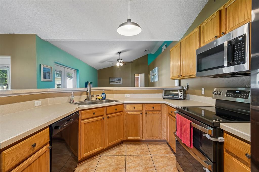 10303 Fordham Street Spring Hill, FL 34608 - Photo 6 of 25 a kitchen with stainless steel appliances a sink stove and cabinets