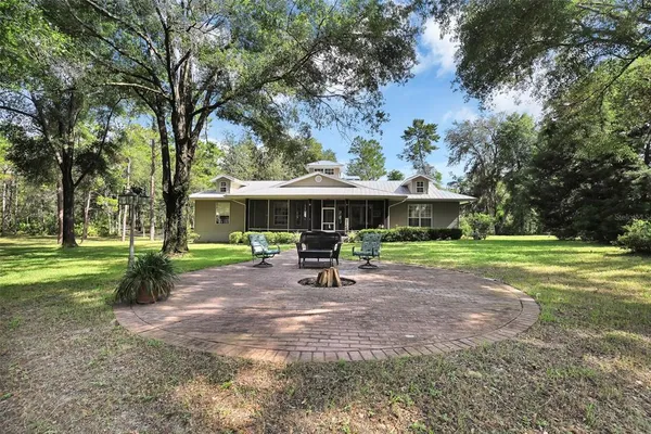 a view of a house with backyard and sitting area