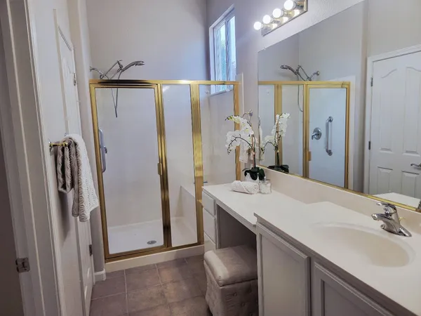a bathroom with a double vanity sink mirror and shower