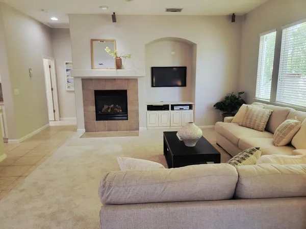 a living room with furniture a flat screen tv and a fireplace