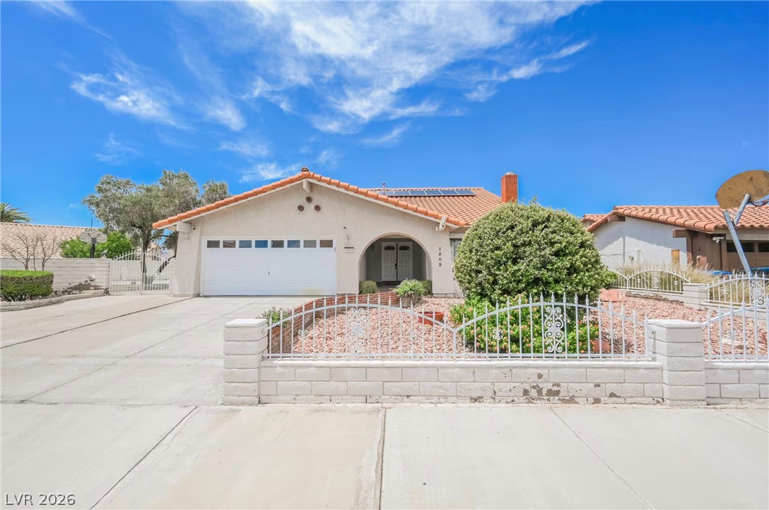 1803 Nuevo Road Henderson, NV 89014 - Photo 1 of 71 Mediterranean / spanish-style house with solar panels, an attached garage, stucco siding, driveway, and a gate