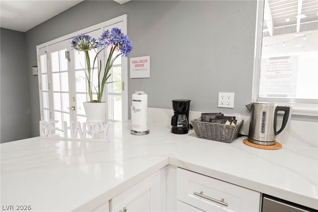 1803 Nuevo Road Henderson, NV 89014 - Photo 14 of 71 Kitchen view of white cabinetry, light stone counters, and french doors