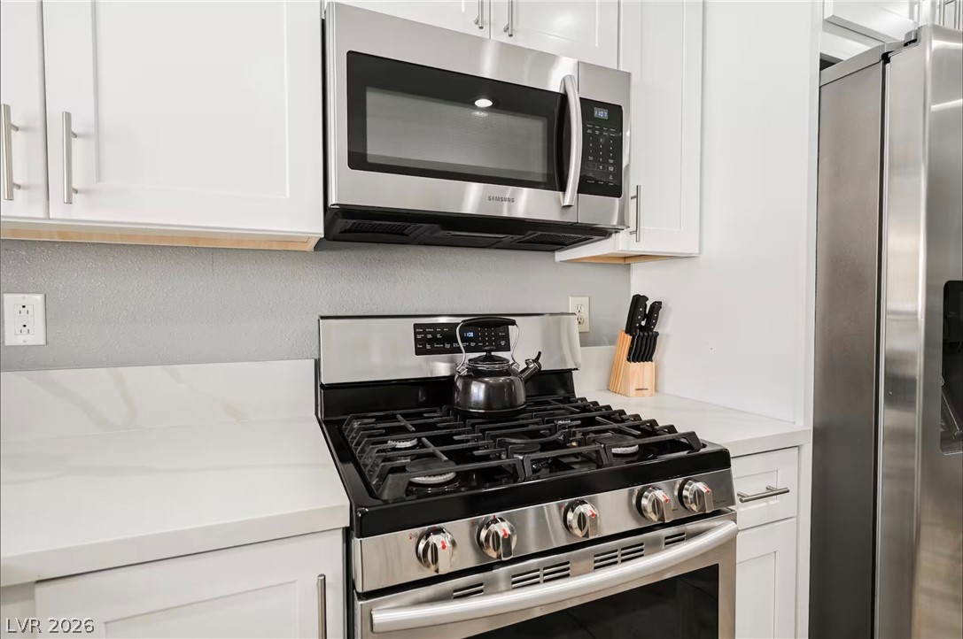1803 Nuevo Road Henderson, NV 89014 - Photo 15 of 71 Kitchen featuring stainless steel appliances and white cabinets