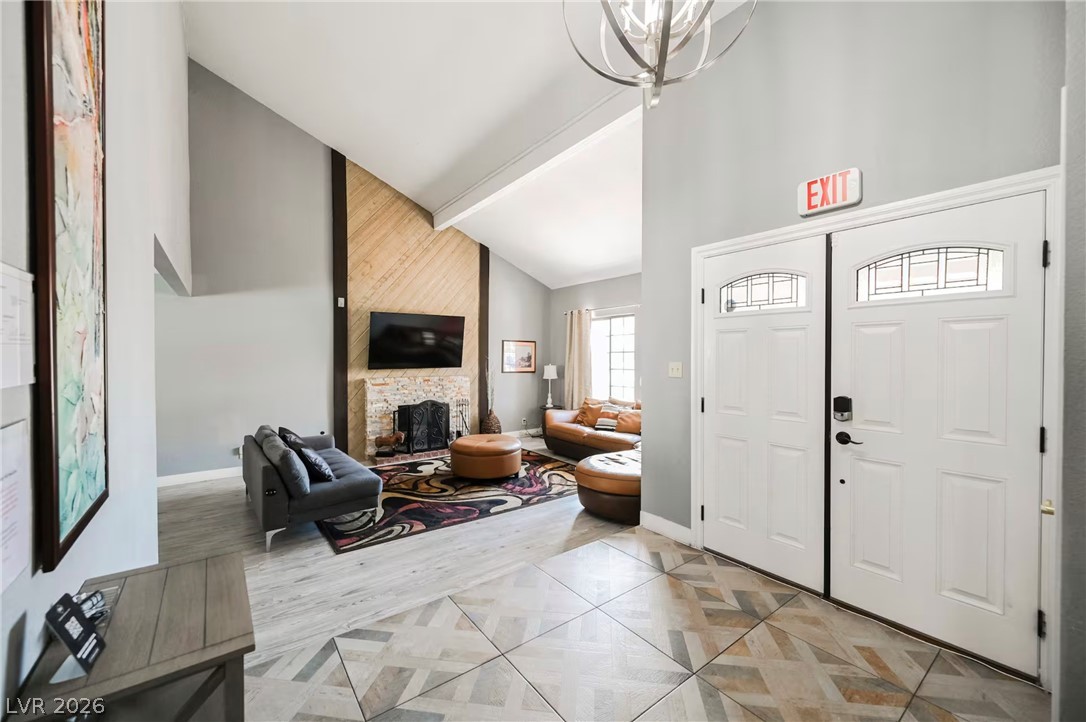 1803 Nuevo Road Henderson, NV 89014 - Photo 2 of 71 Foyer entrance with light wood-style floors, lofted ceiling, a fireplace, and a chandelier
