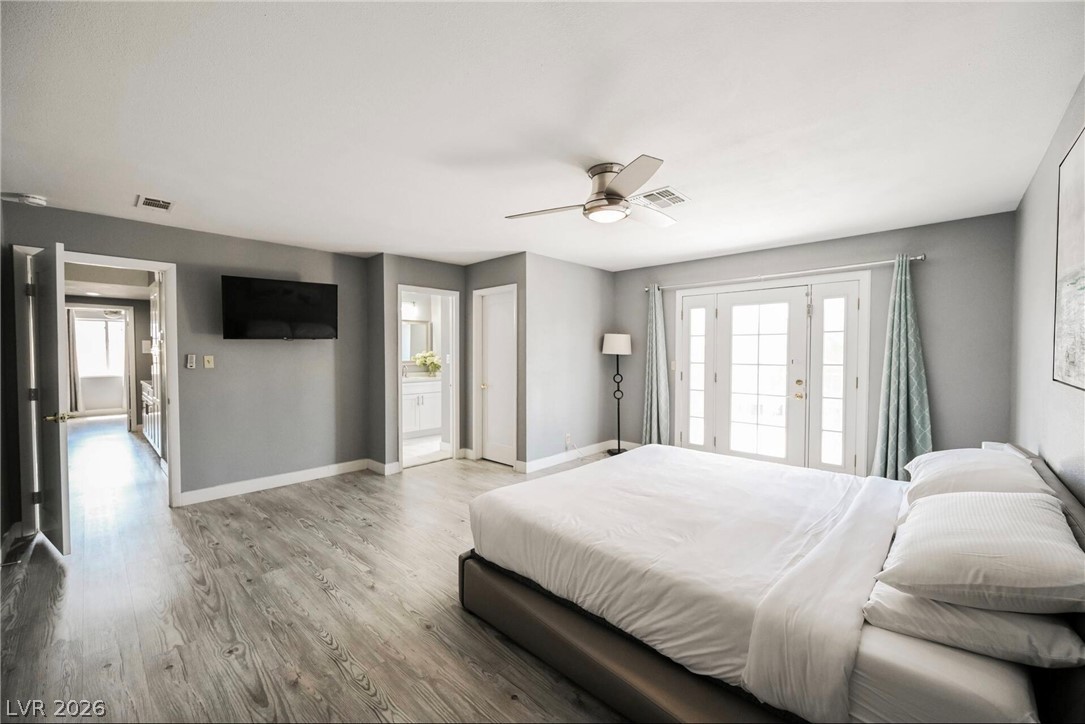 1803 Nuevo Road Henderson, NV 89014 - Photo 25 of 71 Bedroom featuring wood finished floors, a ceiling fan, and ensuite bath