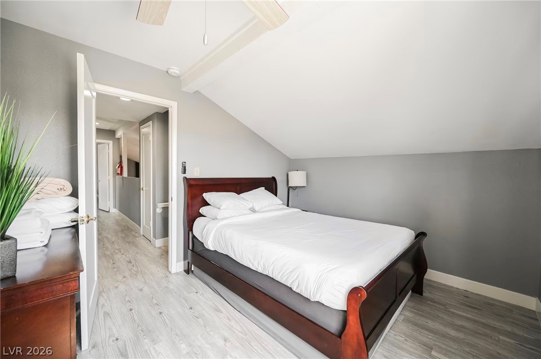 1803 Nuevo Road Henderson, NV 89014 - Photo 30 of 71 Bedroom featuring vaulted ceiling with beams, light wood-style floors, and a ceiling fan