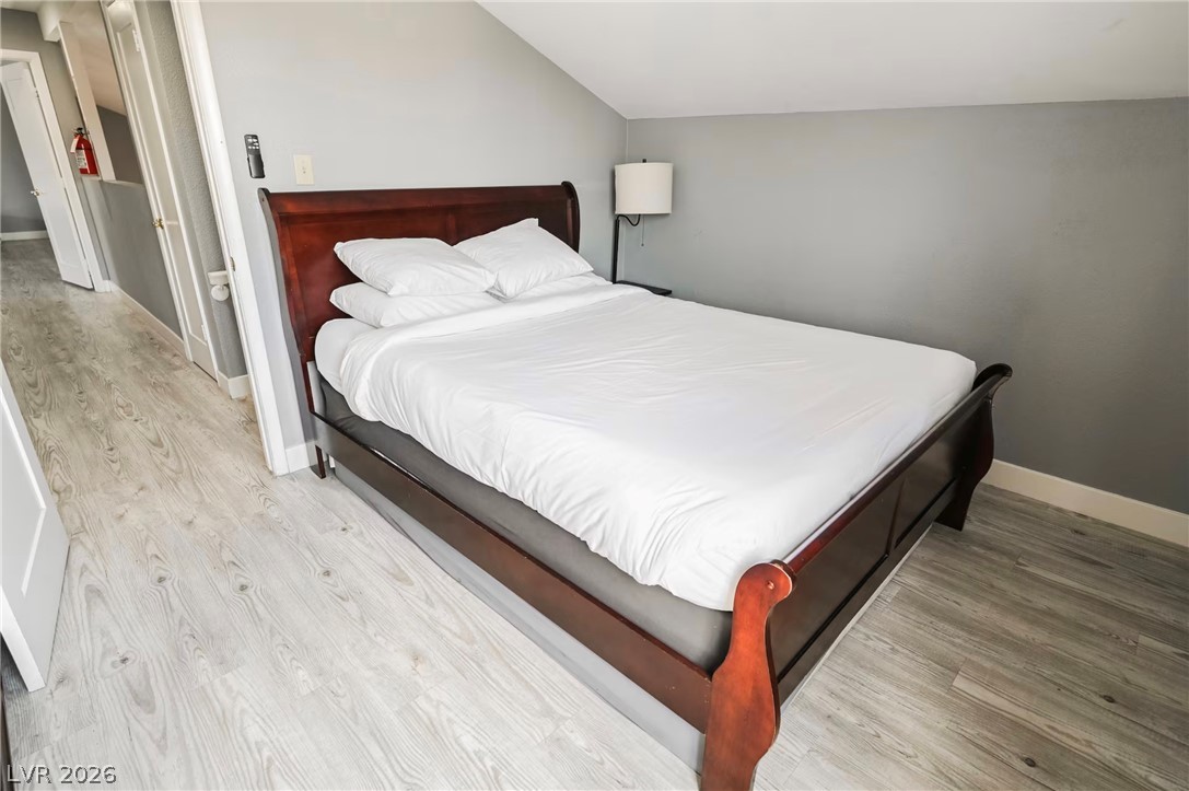 1803 Nuevo Road Henderson, NV 89014 - Photo 33 of 71 Bedroom with vaulted ceiling and light wood finished floors