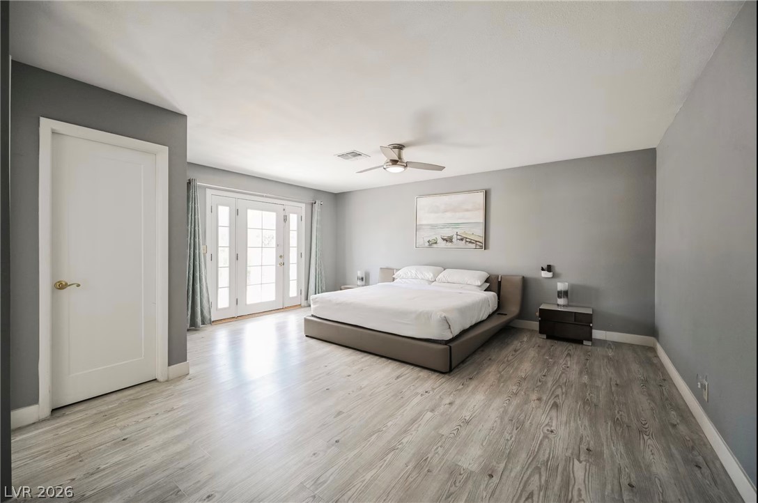 1803 Nuevo Road Henderson, NV 89014 - Photo 35 of 71 Bedroom featuring access to exterior, light wood-type flooring, and a ceiling fan