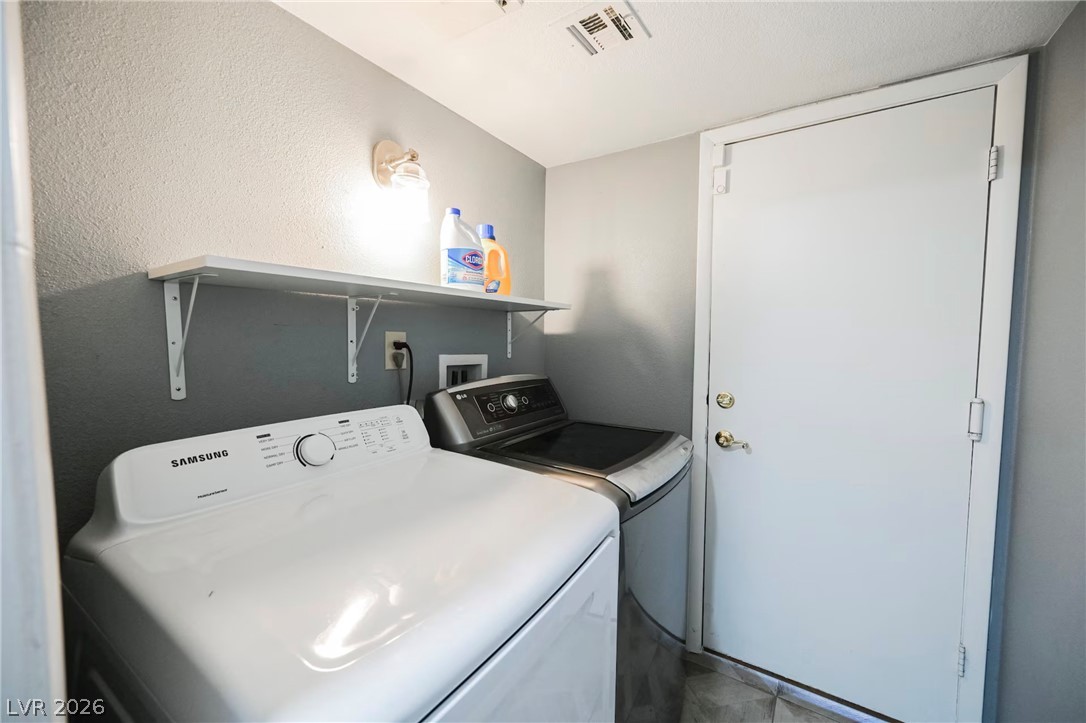 1803 Nuevo Road Henderson, NV 89014 - Photo 50 of 71 Laundry area with washer and dryer and a textured wall