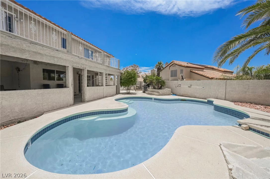 1803 Nuevo Road Henderson, NV 89014 - Photo 59 of 71 View of swimming pool featuring patio surround, a fenced backyard, and a balcony