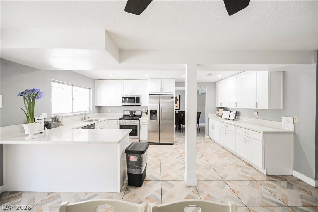 1803 Nuevo Road Henderson, NV 89014 - Photo 10 of 71 Kitchen with ceiling fan, stainless steel appliances, a peninsula, white cabinetry, and recessed lighting