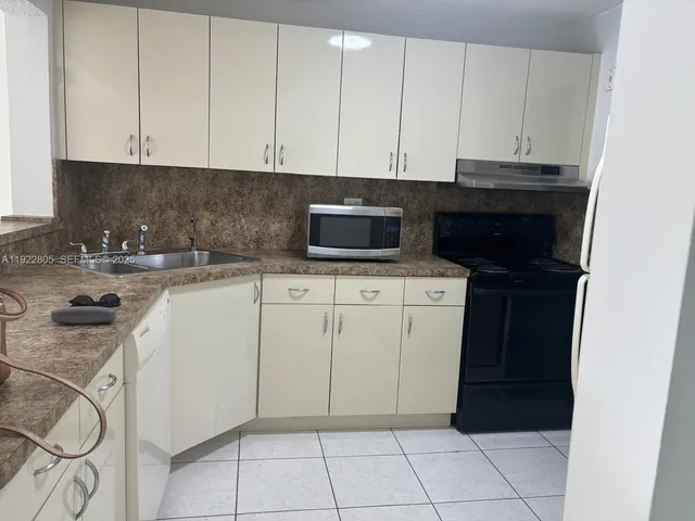 a kitchen with a sink and white cabinets