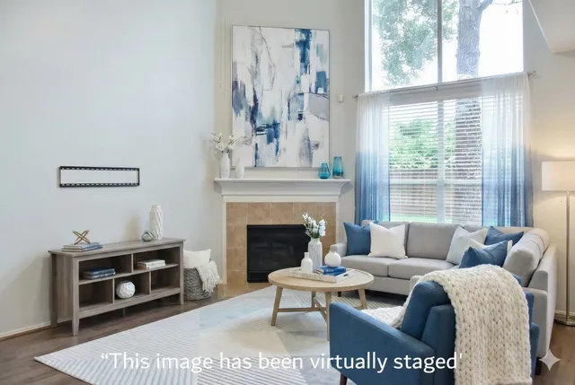 a living room with furniture a fireplace and a large window