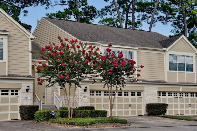 a front view of a house with a yard and potted plants