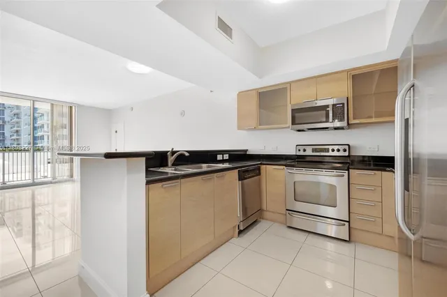 a kitchen with stainless steel appliances granite countertop a refrigerator and a stove top oven