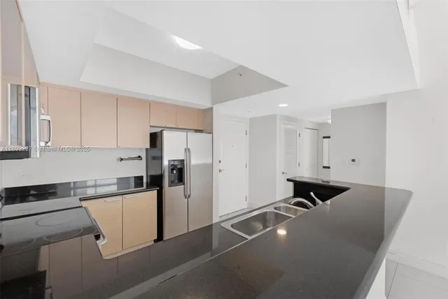 a kitchen with a refrigerator and white cabinets