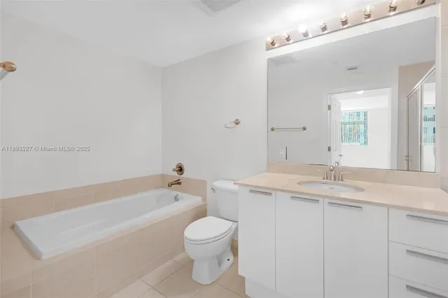 a bathroom with a granite countertop sink a toilet and bathtub