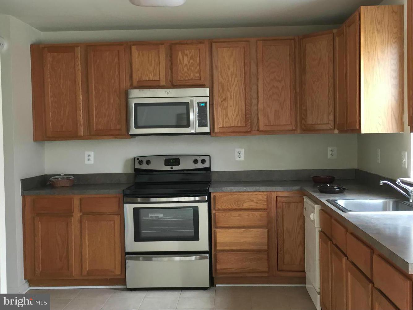 116 Commodore Drive Baltimore, MD 21221 - Photo 13 of 25 a kitchen with granite countertop wood cabinets and stainless steel appliances