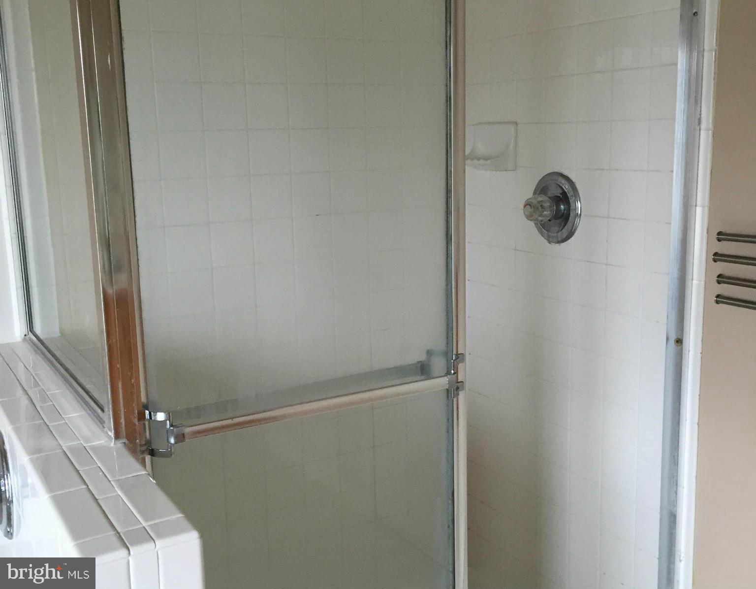 116 Commodore Drive Baltimore, MD 21221 - Photo 22 of 25 a bathroom with a glass shower door