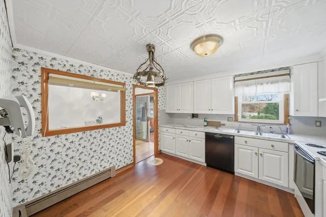 a kitchen with stainless steel appliances granite countertop a sink cabinets and wooden floor