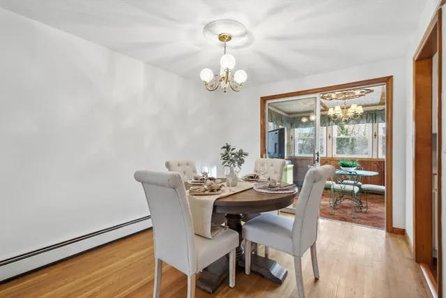 a dining room with furniture a chandelier and wooden floor