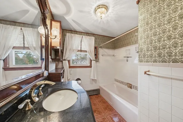 a bathroom with a granite countertop sink a mirror a vanity and a shower