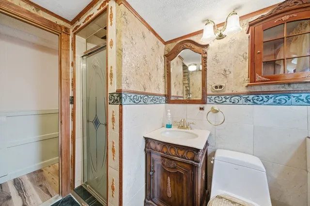 a bathroom with a sink a toilet and shower