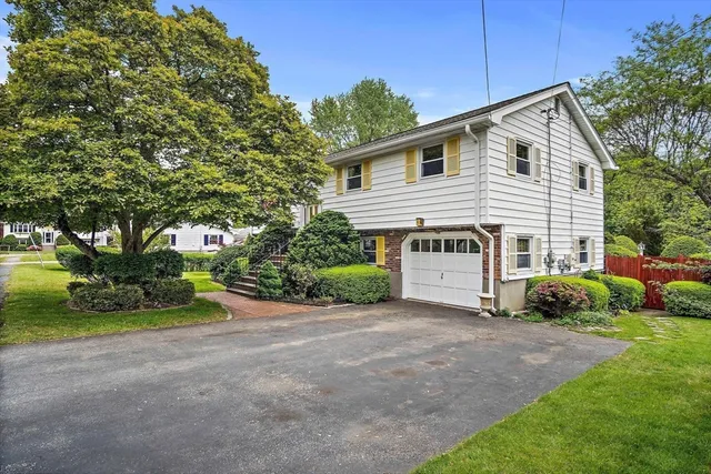 a view of a house with a yard and potted plants