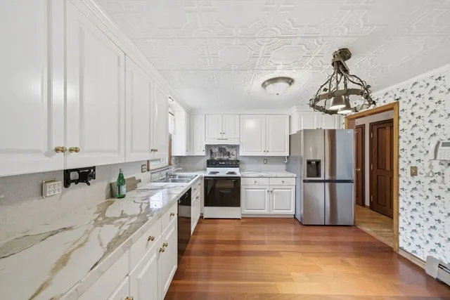 a kitchen with a sink stainless steel appliances and white cabinets