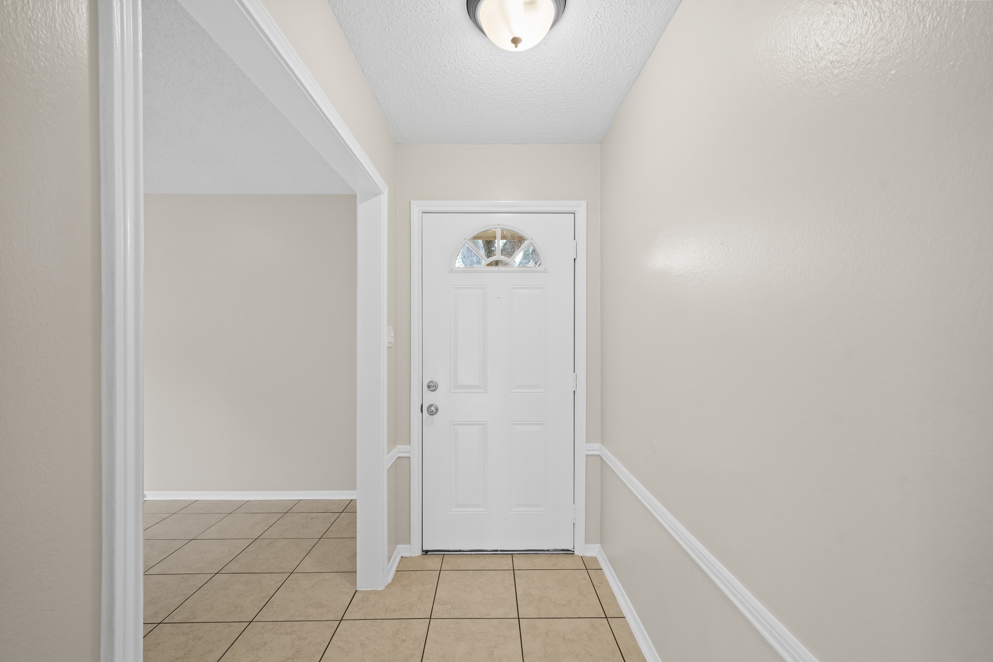 304 Cypress Street Alvin, TX 77511 - Photo 5 of 23 Neat and welcoming entry foyer with tile flooring, chair rail detail, and direct access to the main living spaces.