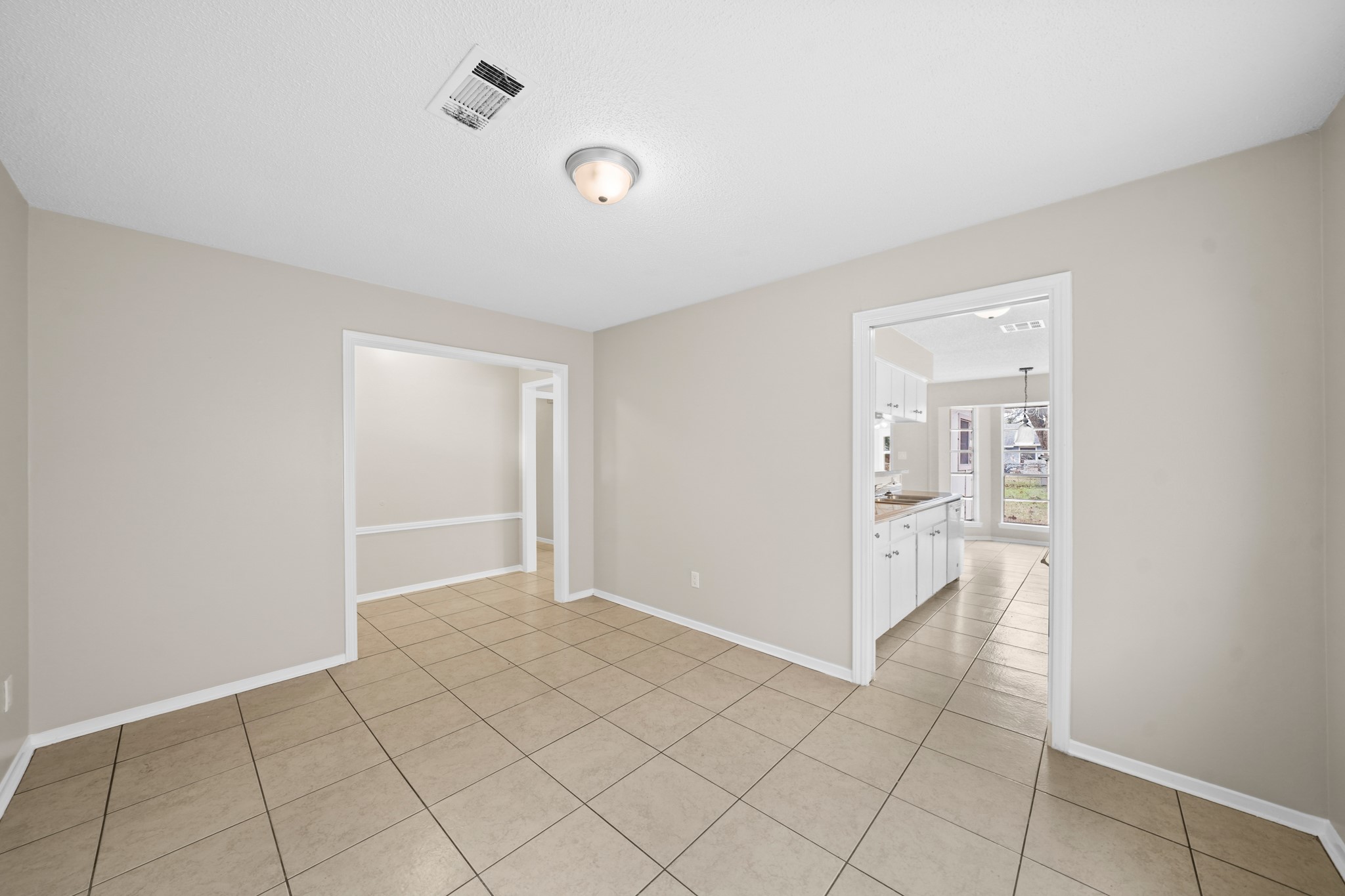 304 Cypress Street Alvin, TX 77511 - Photo 7 of 23 Open dining space with tile flooring and wide openings that create a smooth flow into the kitchen and adjoining living areas.
